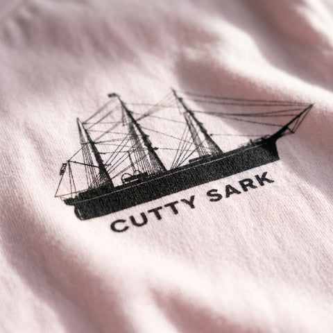 Close-up of a ship logo with 'Cutty Sark' text on a light fabric background