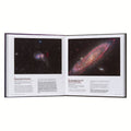 Open book showing images of galaxies on a white background