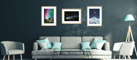 Living room with gray sofa, chairs, and wall art depicting natural landscapes.
