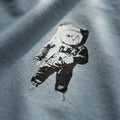 Black and white astronaut graphic on a grey fabric background