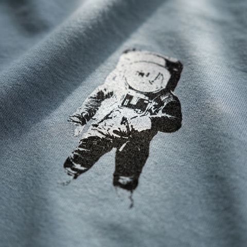 Black and white astronaut graphic on a grey fabric background