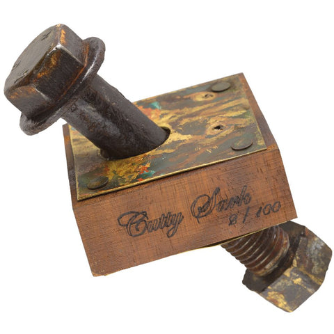 Rustic metal block with a bolt and engraved text on a white background