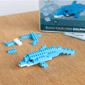 Blue dolphin building block set on a wooden surface with a packaging in the background.
