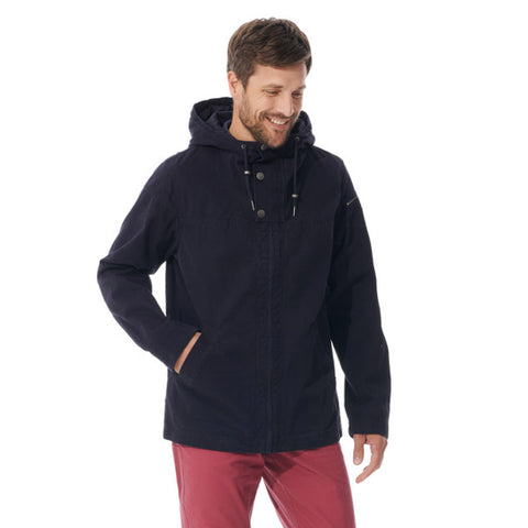 A man wearing a dark navy hooded jacket and red trousers