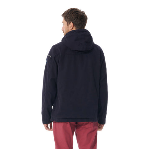 A man viewed from the back wearing a dark navy hooded jacket and red trousers