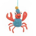 Knitted crab ornament with a blue sweater on a white background