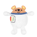 A crocheted plush toy shaped like a bear wearing a white astronaut suit, with a tan head, blue collar, and small embroidered multicolor chest patch