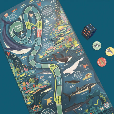 Board game with ocean-themed design, including sharks and marine life, on a blue background.