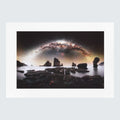 An astophotography print showing a dramatic seascape with sea stacks under a giant galaxy arch in the night sky
