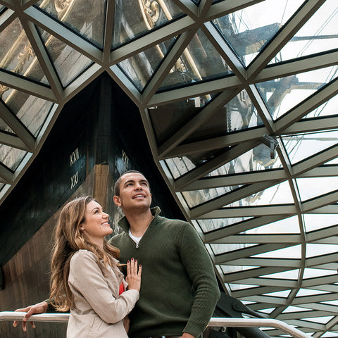 Couple standing together in front of a modern architectural structure with a geometric design.