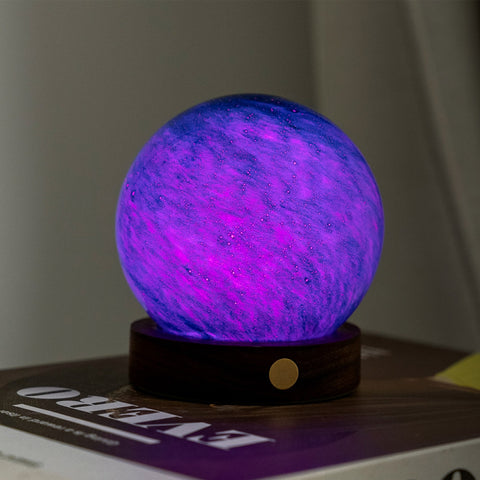 Purple glowing sphere on a wooden base with a blurred background