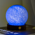Blue spherical lamp on a wooden base with a blurred background