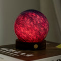 Red glowing sphere on a wooden base with a blurred background