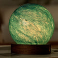 Spherical lamp with green and yellow marbled pattern on a wooden base