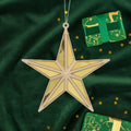 Gold star ornament on a green fabric background with gold stars