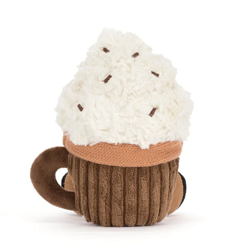 A plush hot chocolate toy shaped like a mug, featuring a fluffy white faux-cream top with small brown sprinkle details, an orange scarf, and a ribbed brown cup with a dark brown handle