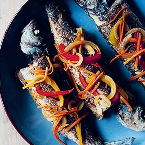 Two whole fish with colorful vegetable strips on a blue plate