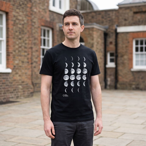 Man wearing a black t-shirt with white moon phase print and 'Royal Museums Greenwich' logo.
