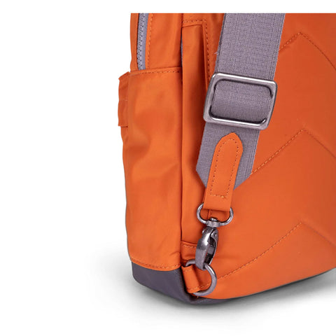 orange crossbody bag with adjustable shoulder strap, close up of side pocket detail