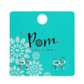 Bow-shaped earrings on a 'Peace of Mind' branded card with floral design