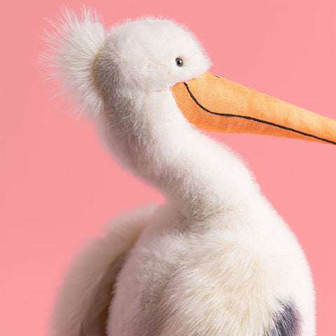 Plush toy pelican on a pink background