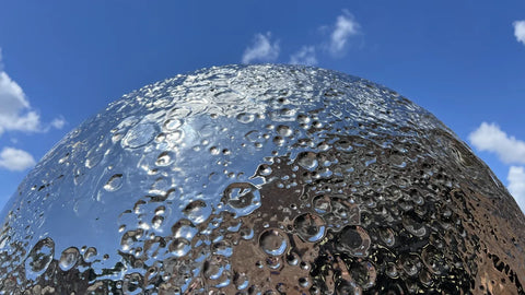 Close-up of a textured metallic surface against a blue sky.