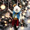 Decorative mouse ornament in a festive setting with Christmas lights and tree.