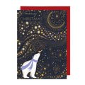 A Christmas greeting card featuring a white polar bear wearing a lavender scarf under a gold crescent moon and starry night sky, with the words 'merry CHRISTMAS' at the top. A red envelope is partially visible behind the card