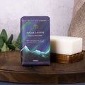 Hand and body soap packaging with a mountain and Northern Lights design on a wooden surface.