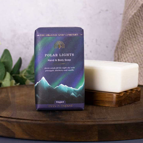 Hand and body soap packaging with a mountain and Northern Lights design on a wooden surface.