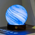 Blue marbled lamp on a dark surface with a blurred background