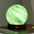 Marble-patterned spherical light on a wooden base with a blurred background