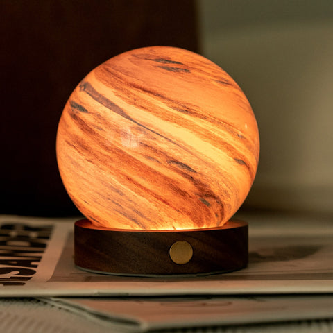 Wooden-textured spherical lamp on a surface with a blurred background
