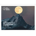 A postcard set cover or package featuring a mountain landscape with a large full moon, with white text reading 'Royal Museums Greenwich' and 'ZWO Astronomy x Photographer of the Year Set of 10 Postcards'.