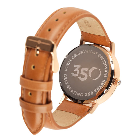 Back of rose-gold watch with tan strap and etched wording: Royal Observatory Greenwich Celebrating 350 Years.