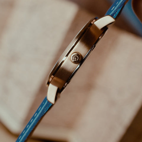 Side view of rose-gold watch with Royal Museum Greenwich logo on the dial.