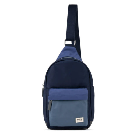 Navy blue crossbody bag with a ROKA brand label on a white background