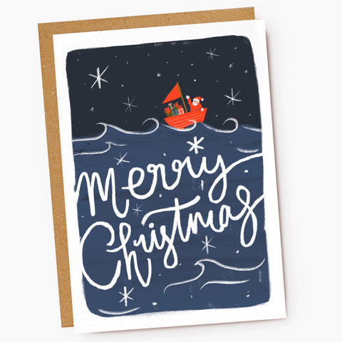 Greeting card with illustration of Santa in a red sailboat and the words Merry Christmas.