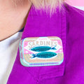 Sardines tin brooch on a purple jacket 