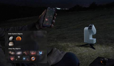 Person using a smartphone app to identify celestial objects with a telescope on a dark night.