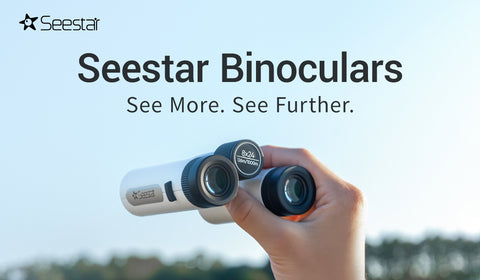 Hand holding ZWO Seestar Binoculars against a blue sky with text reading: "Seestar Binoculars see more see further"