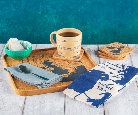 Ceramic mug with a map design on a wooden tray with a blue background