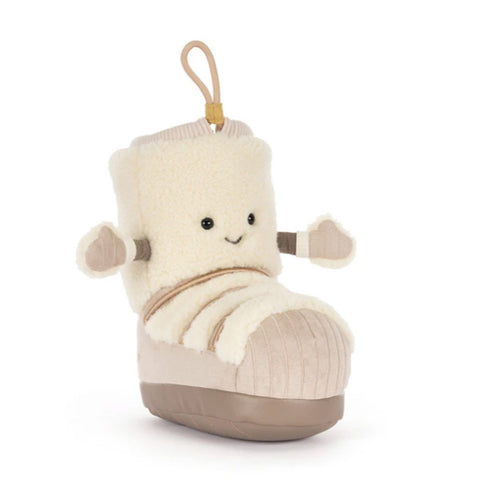 A plush snow boot toy with a cream sherpa upper, beige corduroy-like lower section, and a tan sole, featuring a cute embroidered face and small arm details