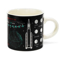 Mug with space-themed design featuring a rocket and celestial elements on a black background.