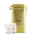 A gold metal tea tin labeled Cartwright & Butler English Breakfast Tea, shown with three white tea bags in front 