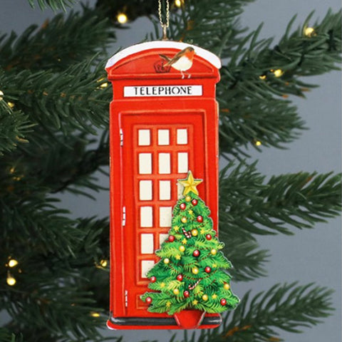 Red telephone box Christmas ornament with a small tree on a green branch background