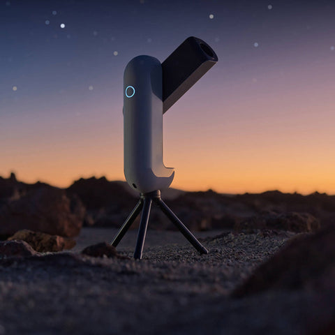 Portable telescope on a tripod against a night sky with stars