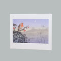 A greeting card with a wide white border shows a stylized landscape scene featuring a robin perched on a branch with red berries, distant mountains, and a pale moon in a lavender sky. 