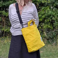 Yellow Cora + Spink Otter tote bag and model