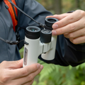 Persons hands adjusting the zoom on ZWO Seestar Binoculars 